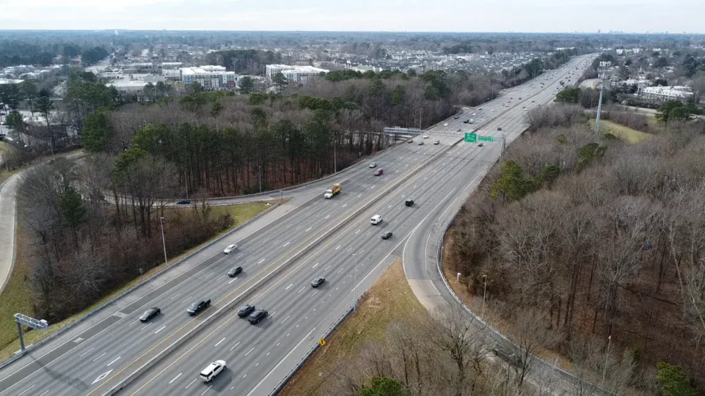 Aerial view of traffic on I-264 in Virginia Beach, with ramps and nearby buildings